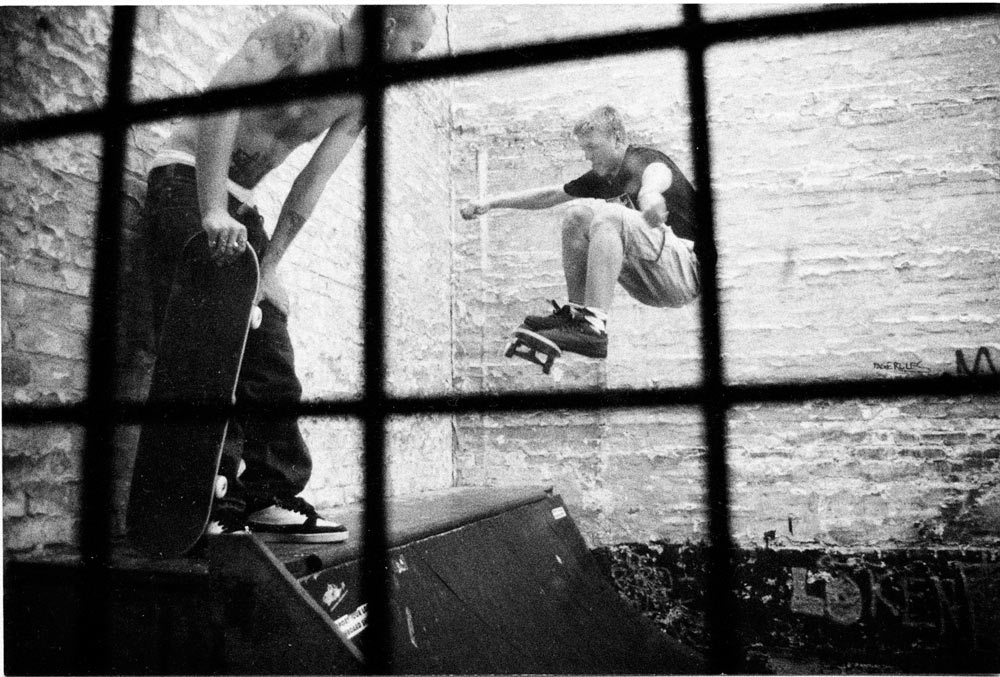 Björn Olofsson kastar ett getöga på Pontus Alvs frontside ollie to smith på Malmös dåvarande skateboardaffär Boards´R Us bakgård. Här samsades Malmös duvor och skatare och heta sessions revs av dagligen på den tighta minin. © Nils Svensson
